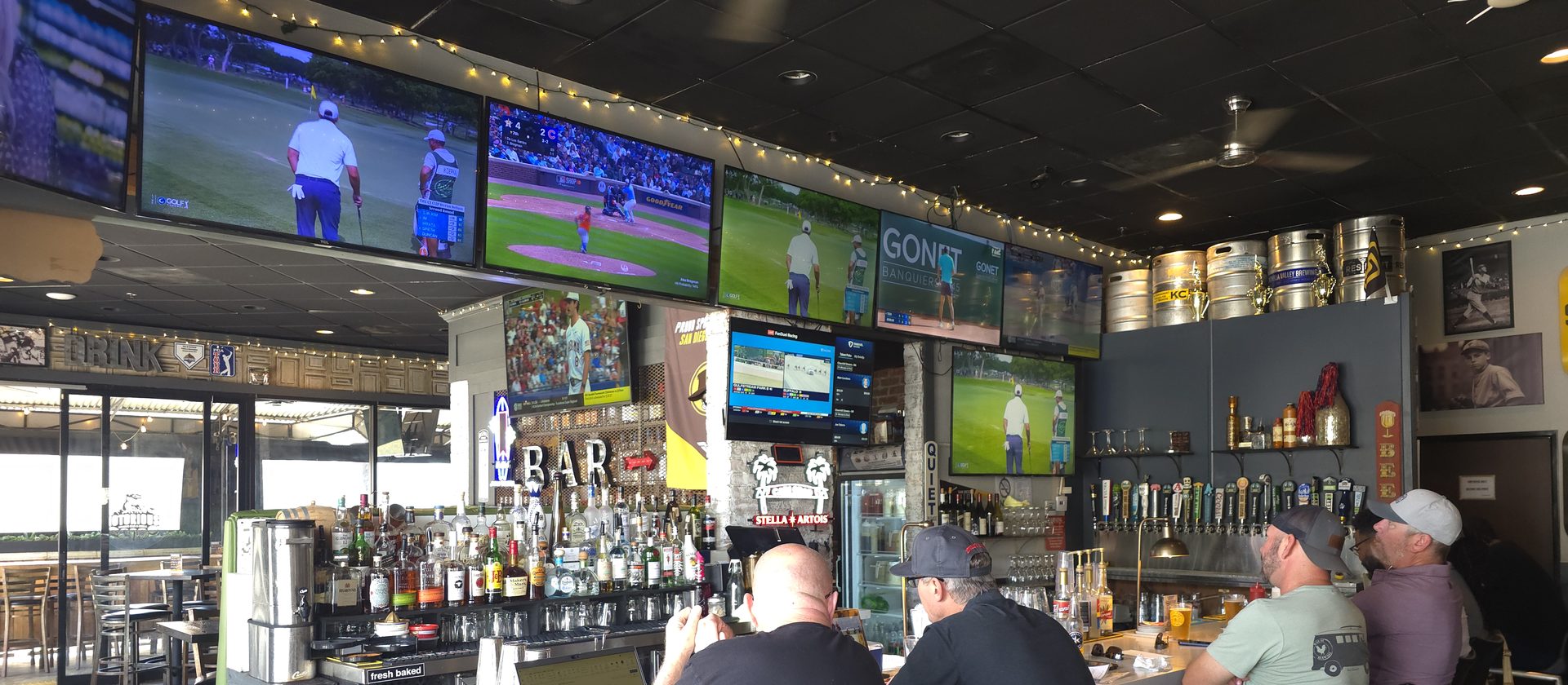 Bar and TV wall at Notorious Sports Bar & Grill in Carlsbad — wide view of the main projector and screens