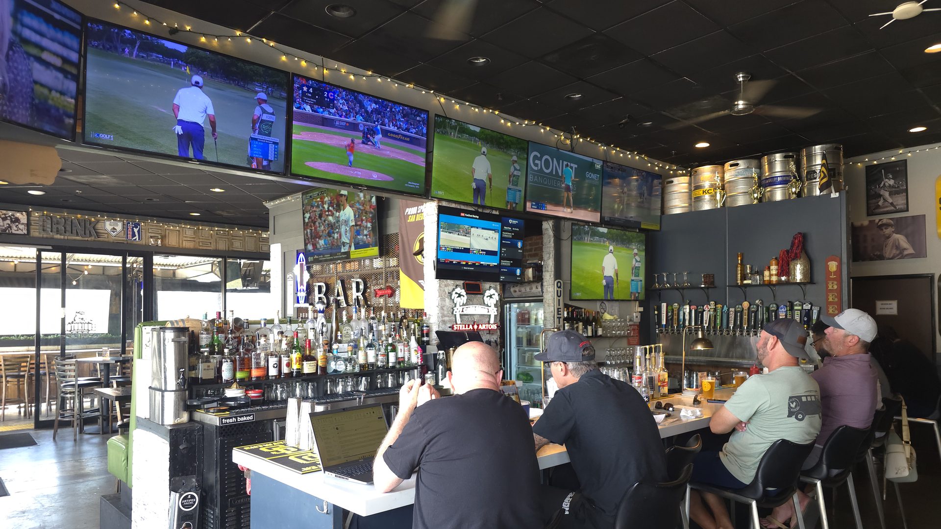The TV wall and bar at Notorious Sports Bar & Grill in Carlsbad — multiple games on screens with guests at the bar